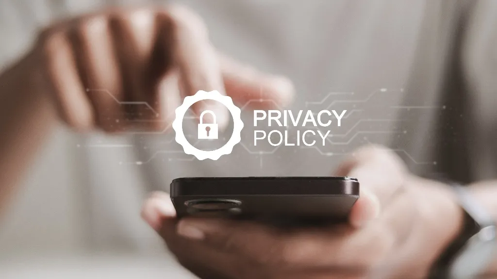 Close-up of a person holding a smartphone with a digital "Privacy Policy" lock icon overlay.